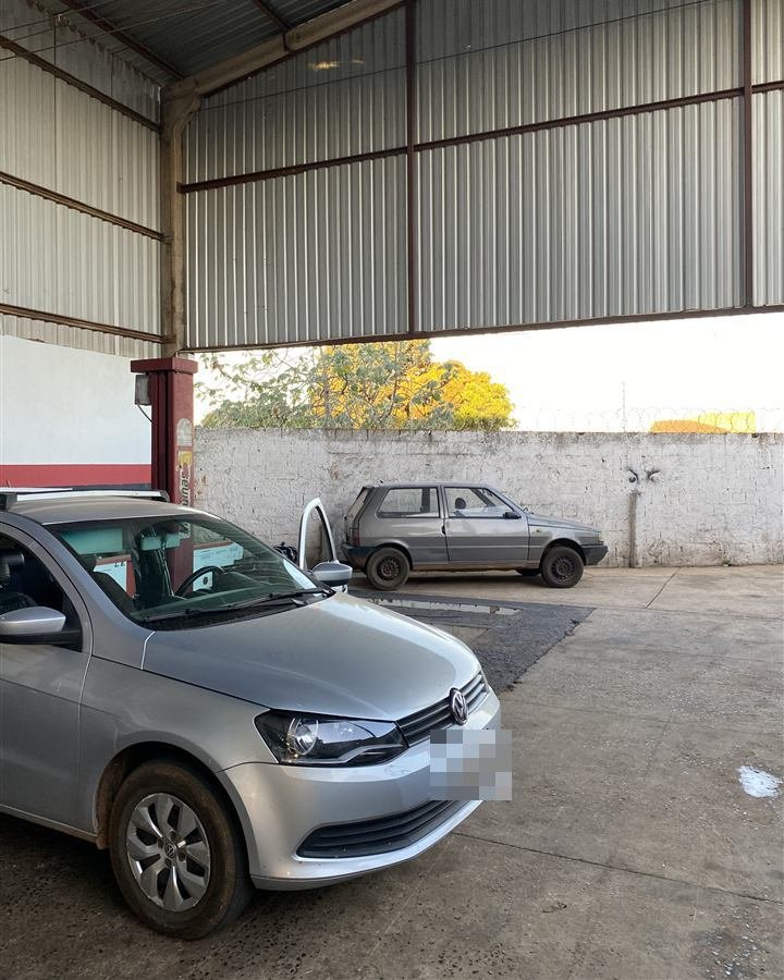 Carro no elevador da oficina Udi Mais, com o pátio ao fundo